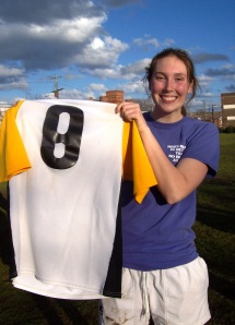 Club treasurer Kyra Kilfeather holds up one of the team's old jerseys.